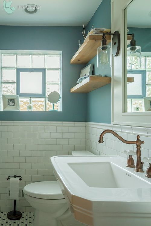 Cuarto de baño con estantes de pared y paredes azules.